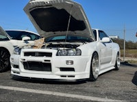 a white nissan gtr parked in a parking lot