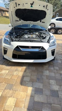 a white nissan gtr with the hood open